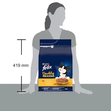 Balení krmiva Felix Doubly Delicious 3 kg opřené o stůl vedle siluety ženy, výška balení je 419 mm.